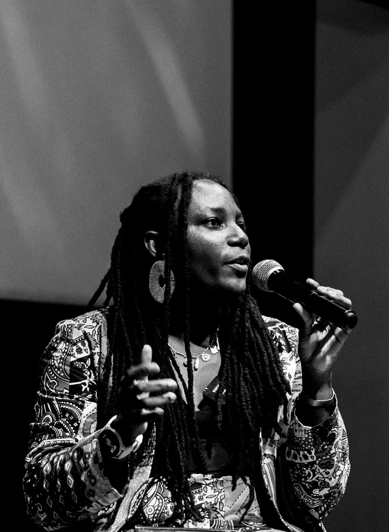 Ema Edosio speaking on stage at a film screening